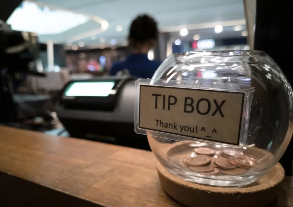 Waitstaff receiving tips from customers in a restaurant setting.